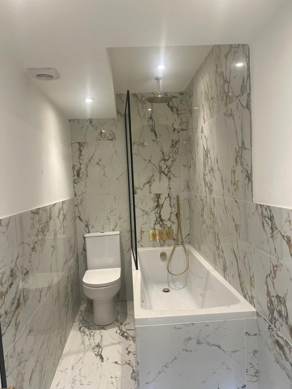 Bathroom marble effect tiling bath gold fittings